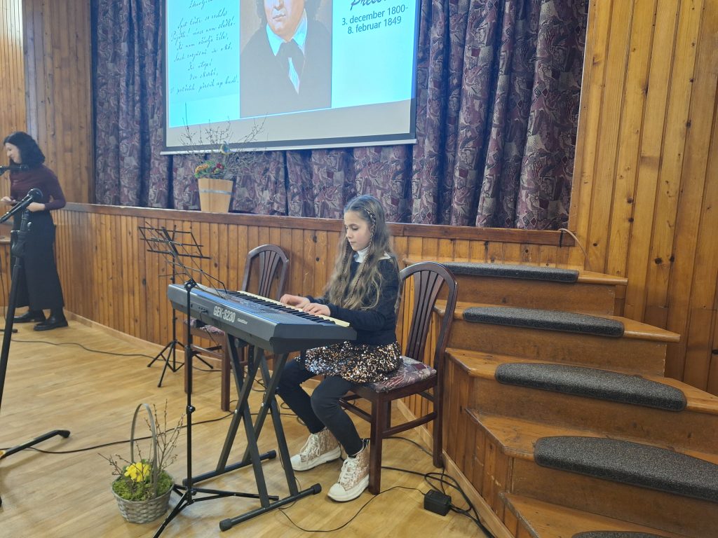 Na fotografiji je deklica, ki igra klavir