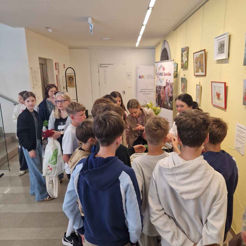 Na sliki so otroci, ki si ogledujejejo izmenjavo rastlin