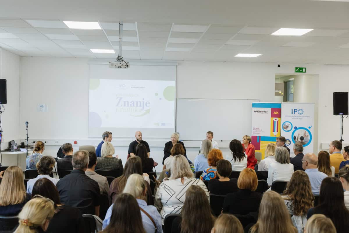 Udeleženci sedijo na konferenci